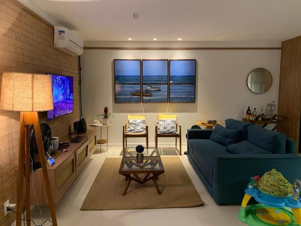 a living room with a blue couch and a table at Pé na areia - Ykutiba - Fantástico in Imbassai