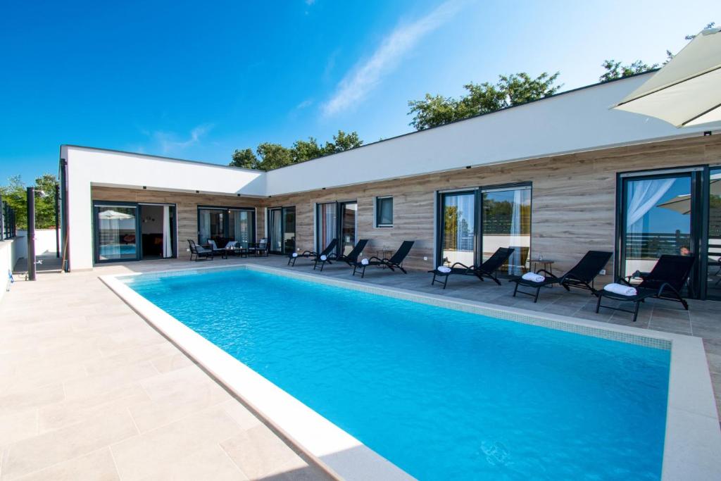 - une piscine en face d'une maison dans l'établissement Ferienhaus Beata mit privatem Pool in Istrien,Vodnjan, à Svetvinčenat