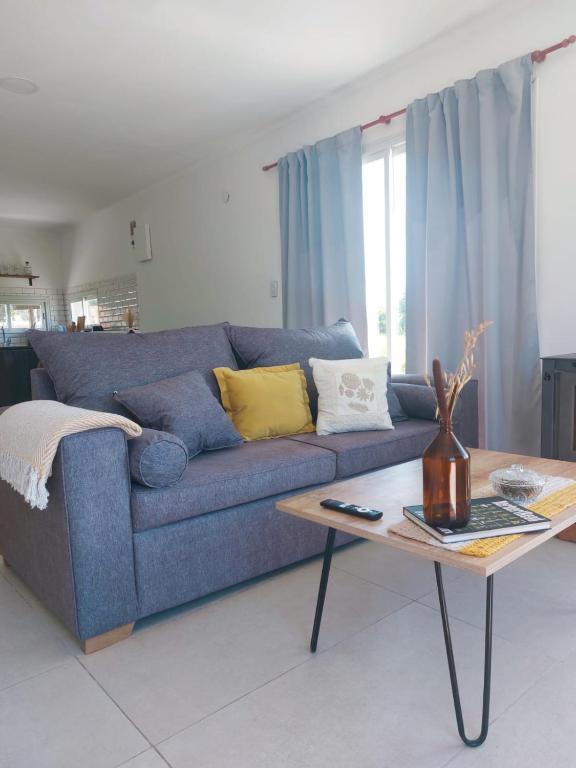 Una sala de estar con un sofá azul y una mesa de café. en Casa en Santa Elena, en Playa Dorada