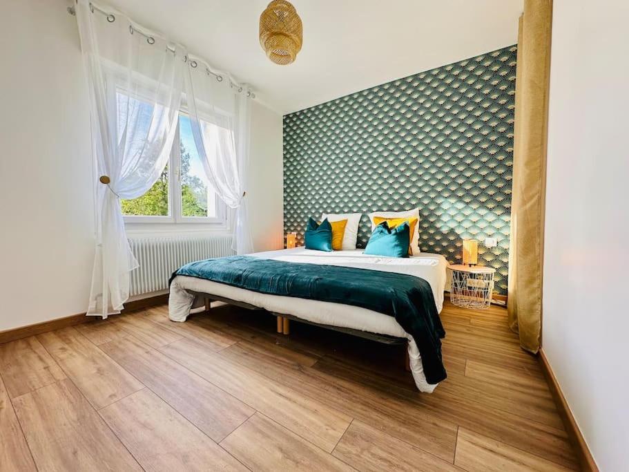 sypialnia z dużym łóżkiem z niebieskimi i żółtymi poduszkami w obiekcie Rés. Marie Galante, Lac du Der 