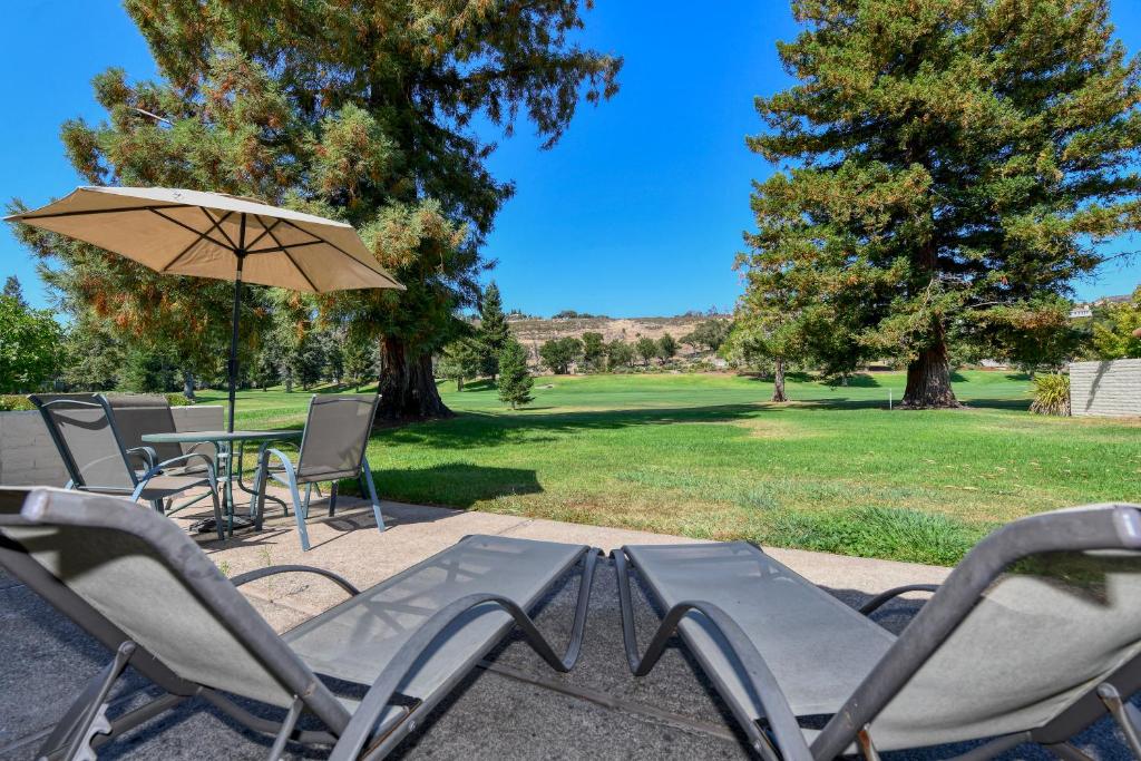 une terrasse avec des chaises, un parasol et une table dans l'établissement Relax in Comfort with Fairway Views at Silverado North Course, à Napa