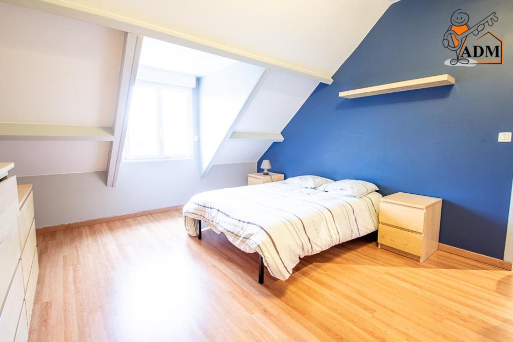 - une chambre avec un mur bleu et un lit dans l'établissement Chez Michel, 