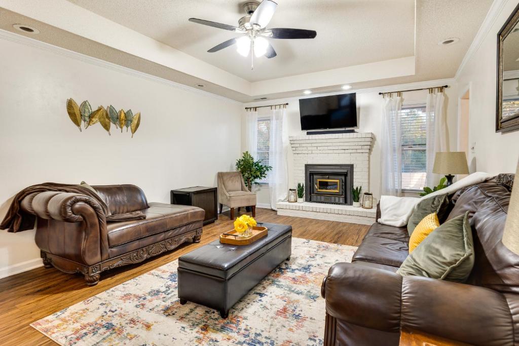 a living room with leather furniture and a fireplace at Spacious Madison Vacation Rental with Backyard! in Madison