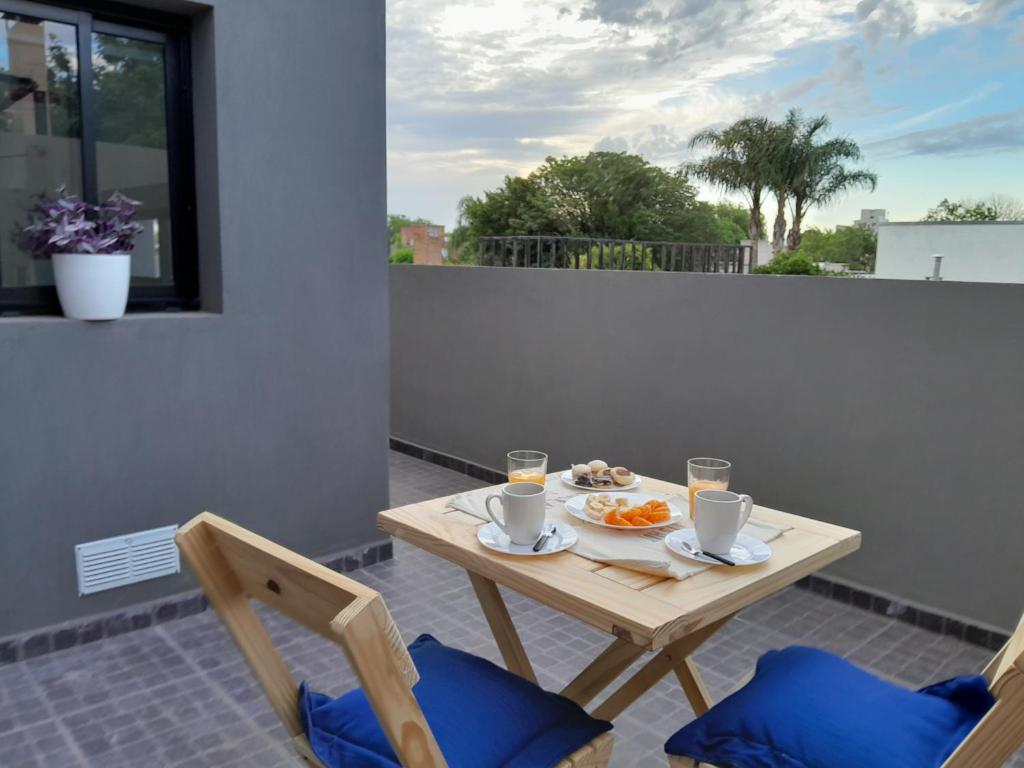 una mesa con un plato de comida en el balcón en Confort urbano - Departamento en Venado Tuerto