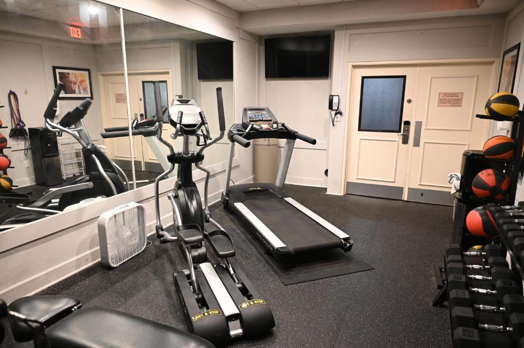 a gym with a treadmill and a elliptical machine at Savai Hotel in Overland Park