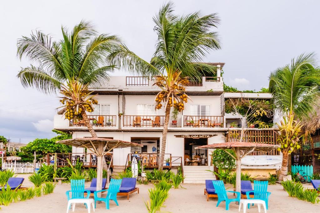 un hotel en la playa con sillas y palmeras en Hotel Casa Sattva- Bed & Breakfast, en Rincón