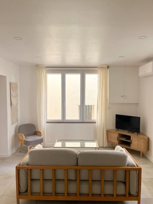 un salon avec un canapé et une télévision dans l'établissement Les Bords de l'Estaque x Le refuge de Cézanne, à Marseille