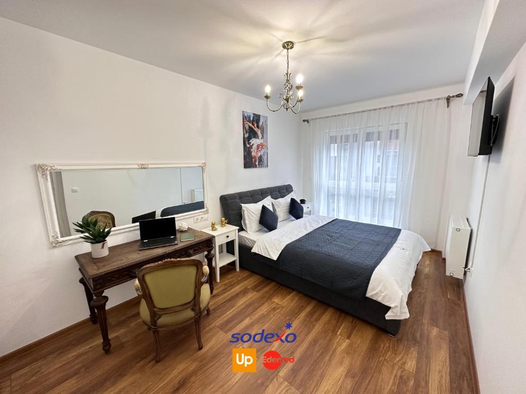 Schlafzimmer mit einem Schreibtisch und einem Bett mit einem Laptop in der Unterkunft Cozy Apartments at Maurer Residence Brasov in Braşov