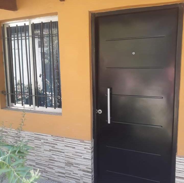 une porte noire avec une fenêtre à côté de celle-ci dans l'établissement Departamentos Carhue, à Carhué