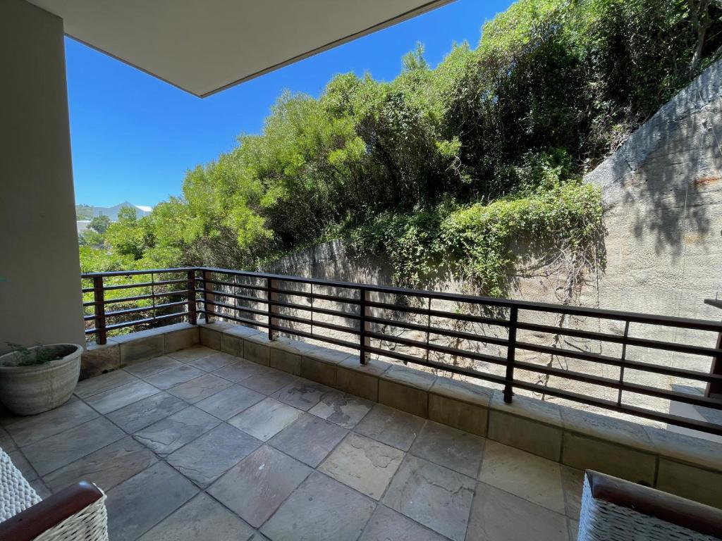 a balcony with a view of a wall and trees at The Herolds Bay 611 in Herolds Bay