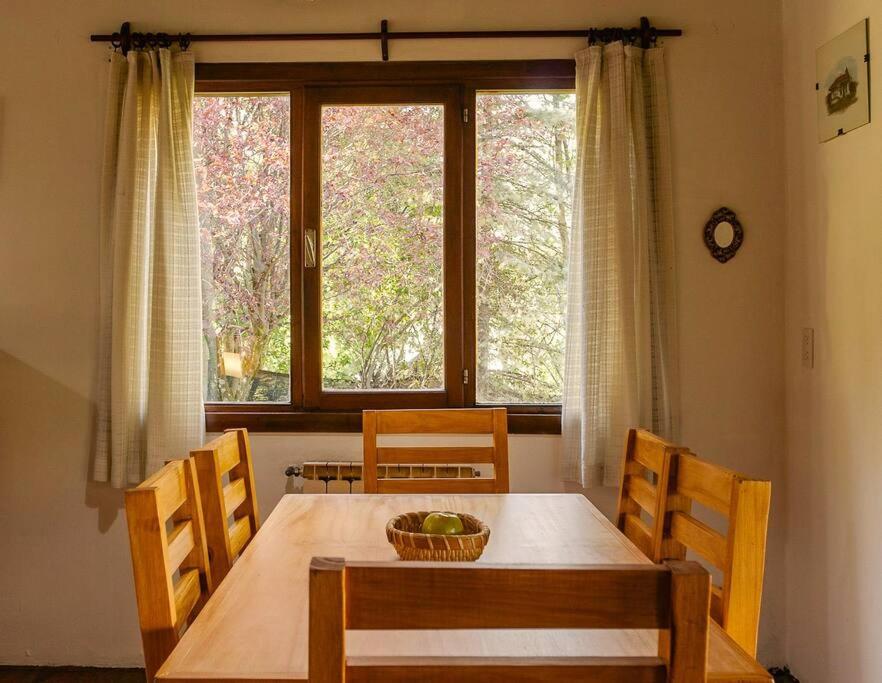 d'une salle à manger avec une table, des chaises et une fenêtre. dans l'établissement Tu Apart en Bariloche 27, à San Carlos de Bariloche