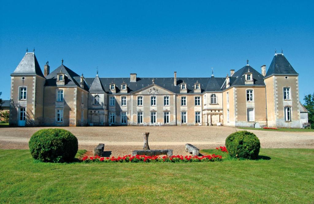 un gran castillo con una estatua delante de él en Château de Panloy, en Port-dʼEnvaux