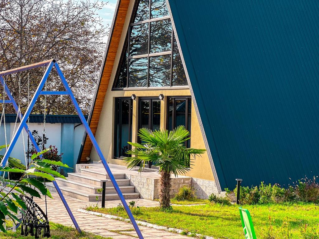 a blue building with a palm tree in front of it at Qafqaz Mountain Chalet in Gabala