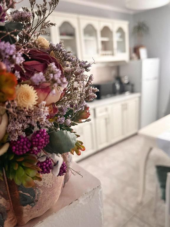 un ramo de flores sentado en un mostrador en una cocina en Ingrid Residence, en Ocna-Mureşului