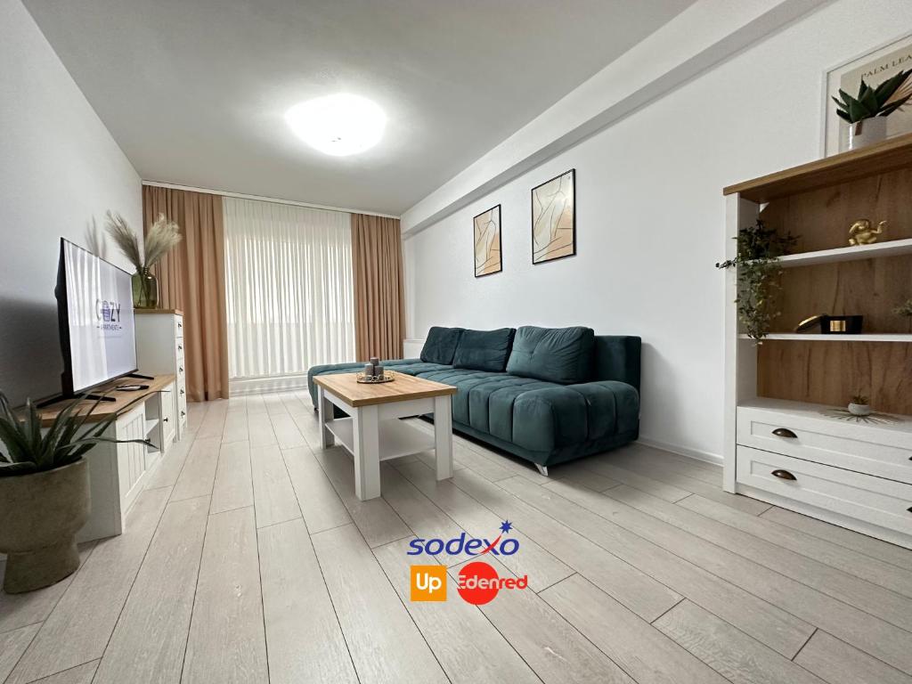 a living room with a blue couch and a table at Cozy Luxury Apartments - Coresi Mall #Brasov in Braşov