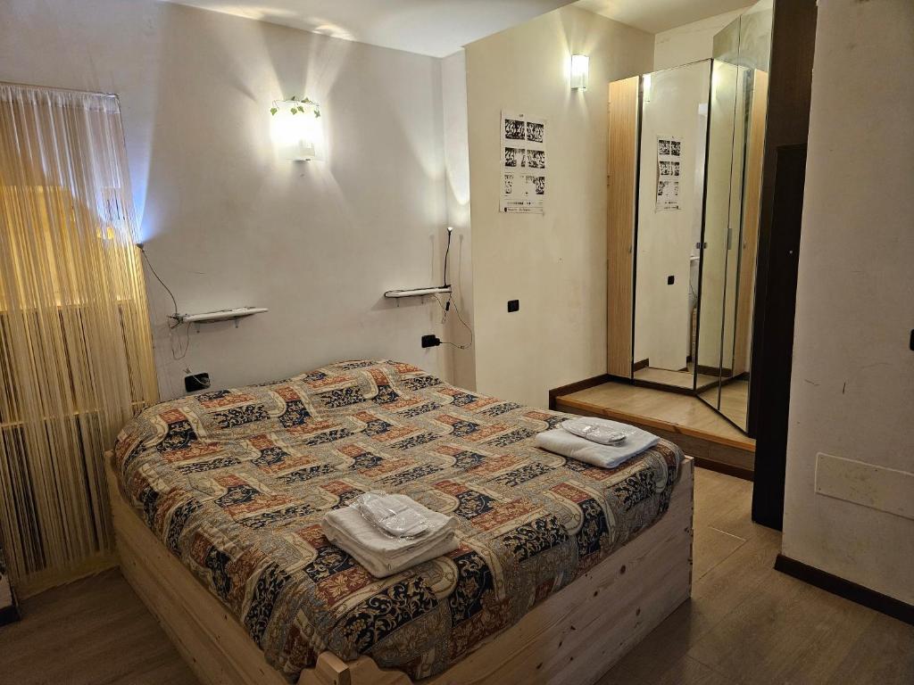 um quarto com uma cama com duas toalhas em Nel Vicolo Nascosto em Legnano