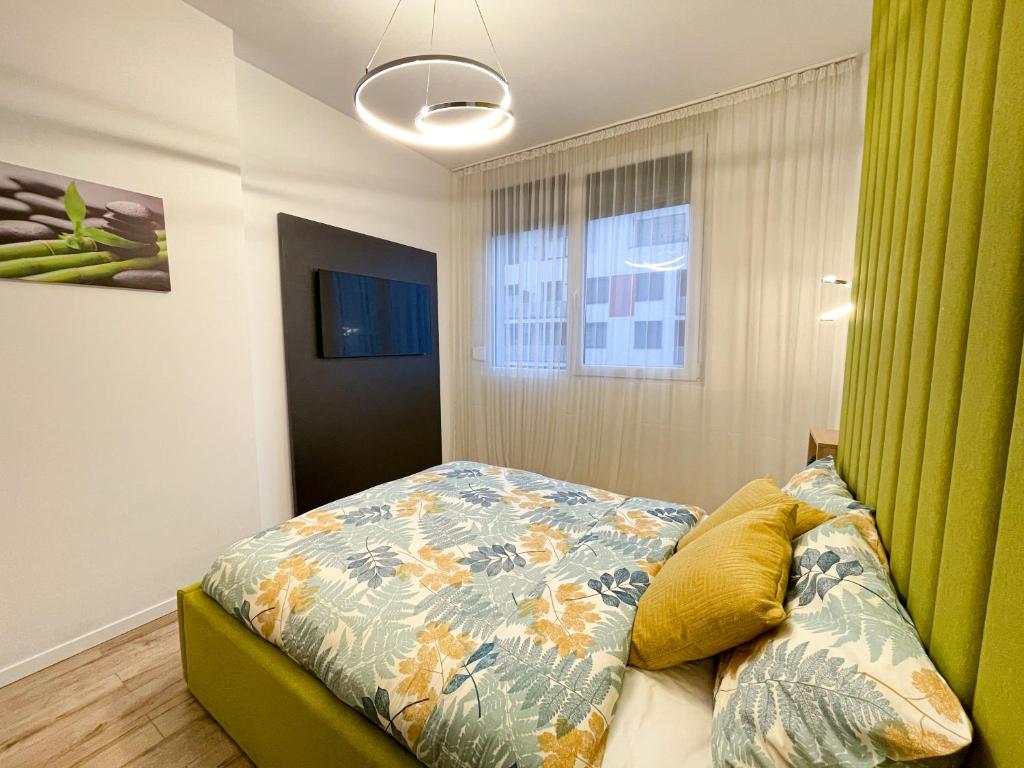 a bedroom with a bed and a window at Emerald Apartment in Arad