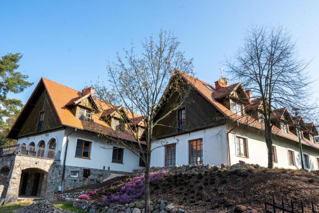 una casa blanca con techo marrón en Wrzosowe Love, en Raciąż