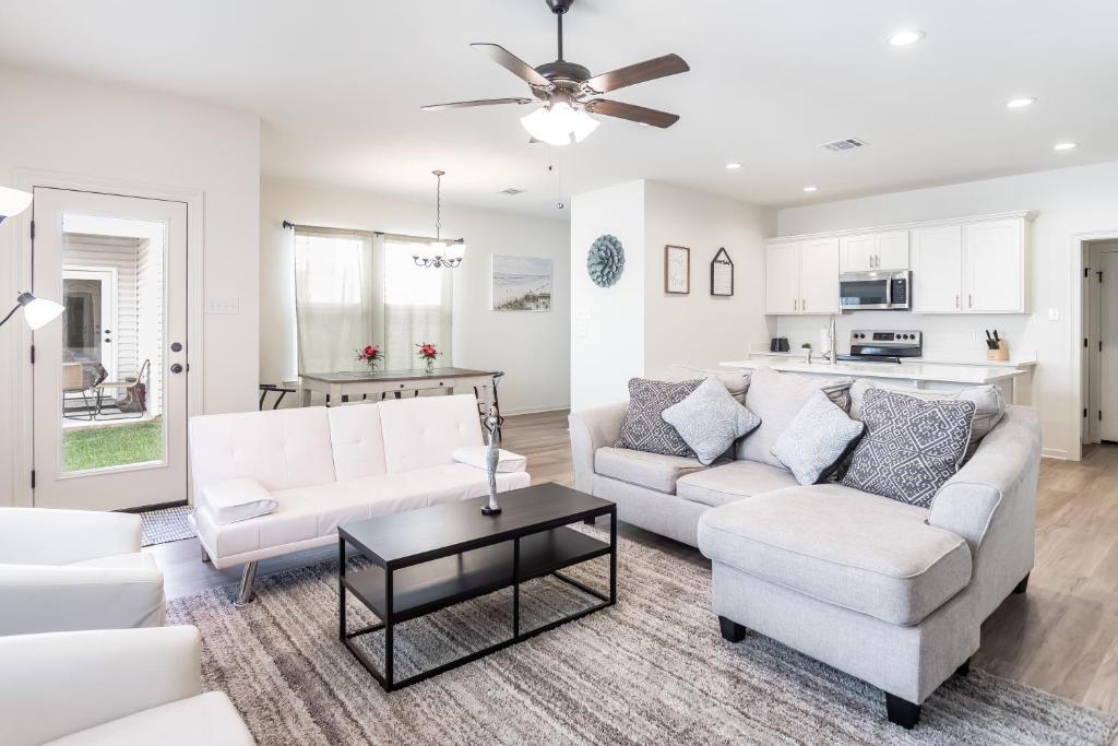 a living room with two white couches and a table at Luxury Townhome by LSU campus in Baton Rouge