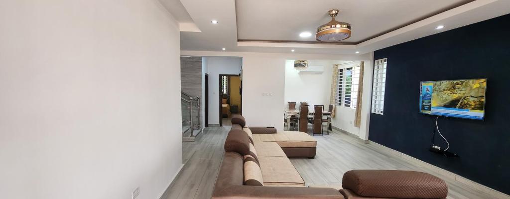 sala de estar con sofá y TV en Jab Duplex, en Adentan