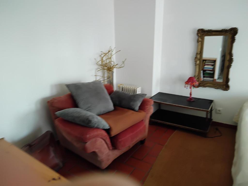 a living room with a red couch and a mirror at Great duplex in historical center in Lisbon