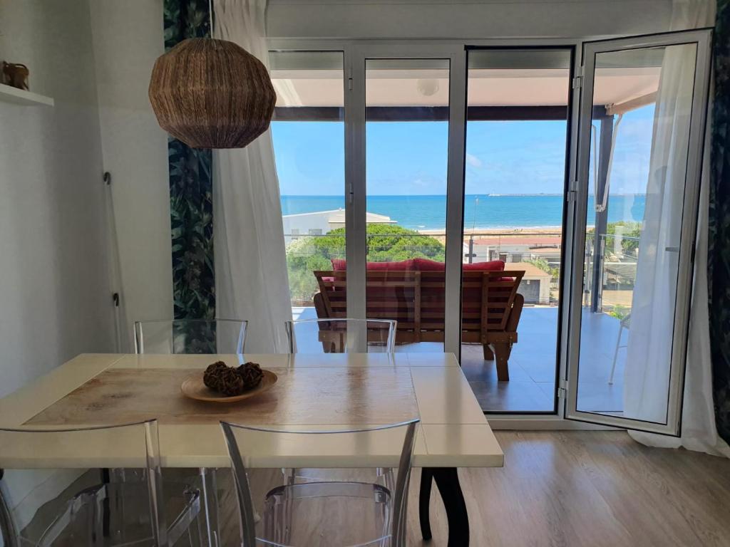 a dining room with a table and a view of the ocean at Mazagón relaj in Palos de la Frontera