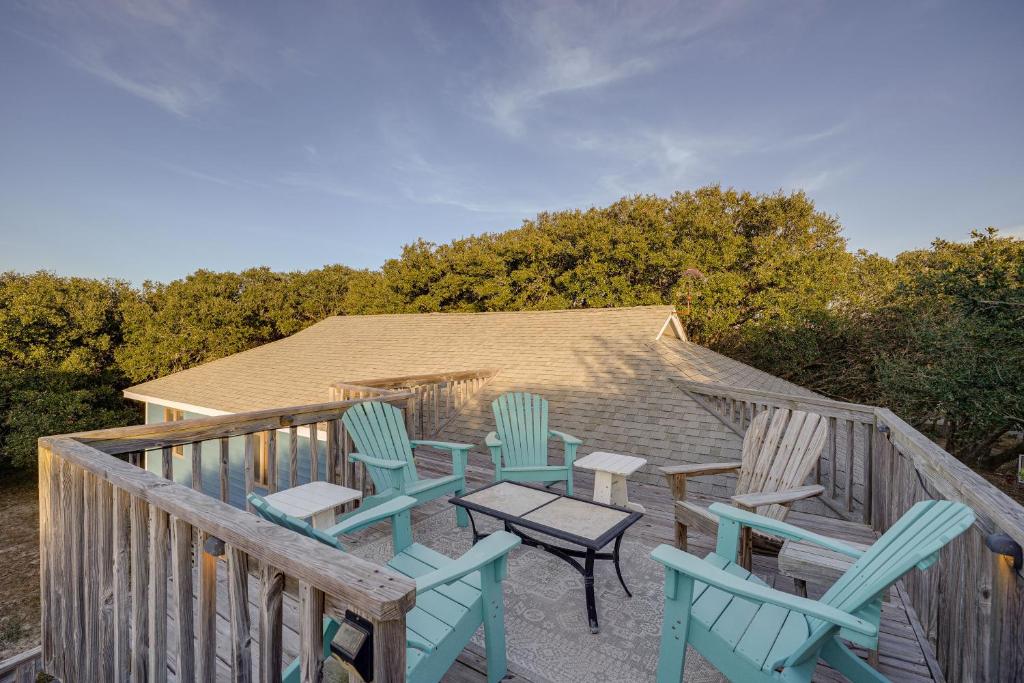 4 sillas y una mesa en una terraza con una casa en Outer Banks Retreat - Walk to Beach!, en Southern Shores