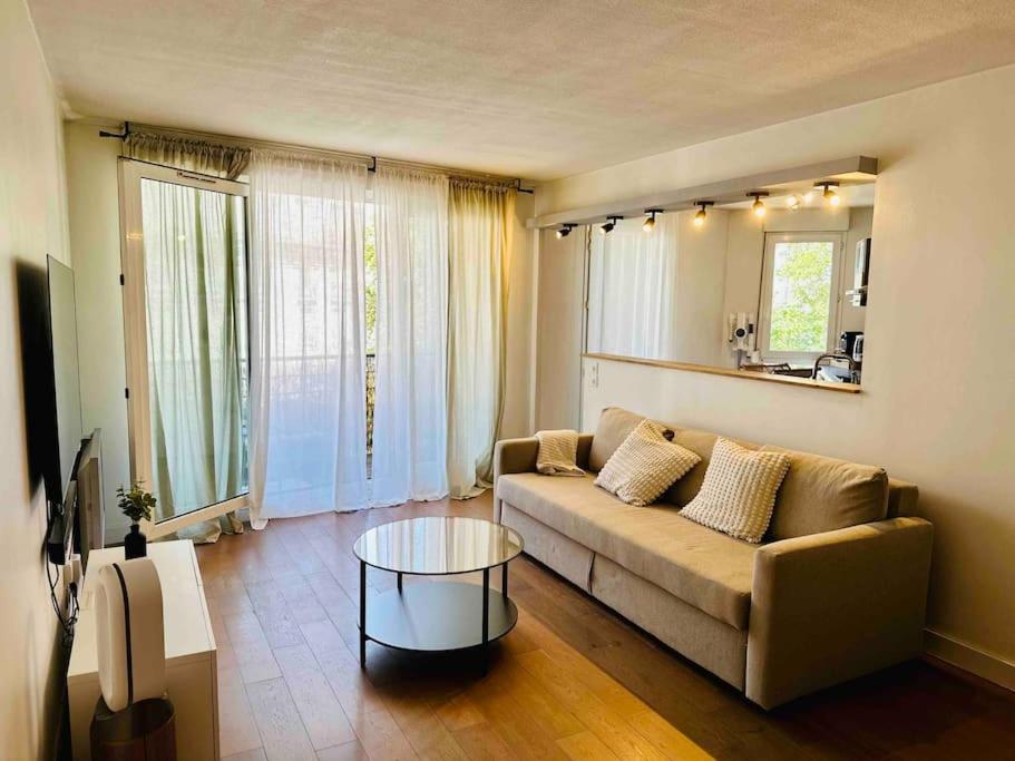 ein Wohnzimmer mit Sofa und Tisch in der Unterkunft Appartement lumineux et spacieux proche gare in Villeurbanne