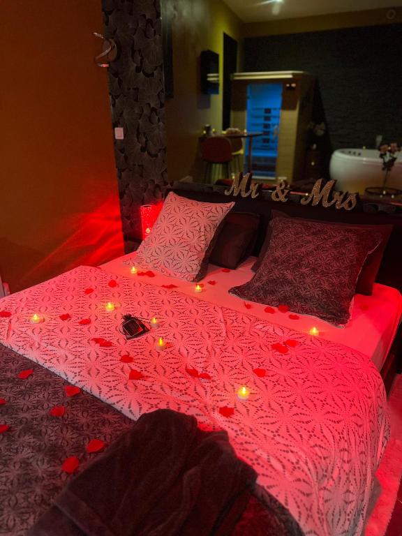 a bed with a red comforter with lights on it at HomeSparadise Loveroom in Besançon