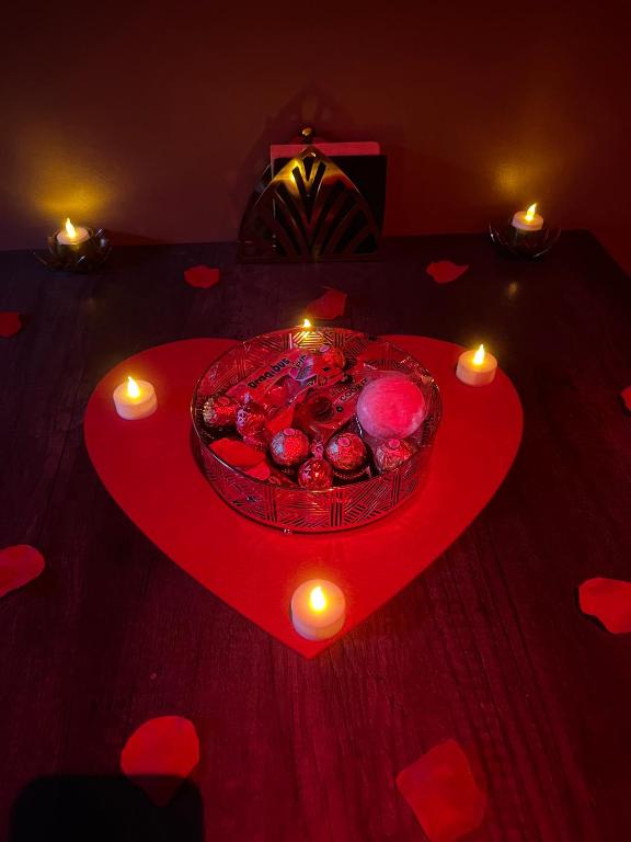 a table with a bowl of apples on a heart with candles at HomeSparadise Loveroom in Besançon