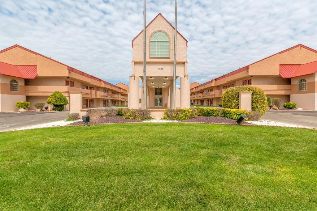 a large building with a green lawn in front of it at HomeTowne Studios by Red Roof Amarillo West in Amarillo