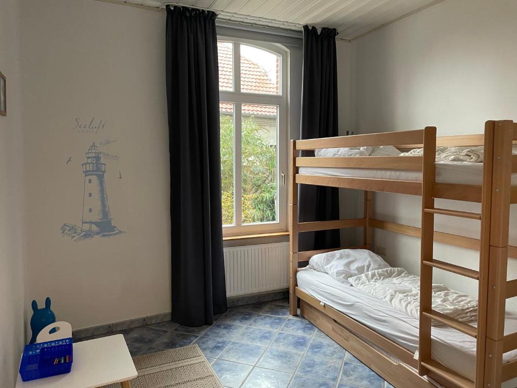 een slaapkamer met 2 stapelbedden en een raam bij Ferienwohnung Lavendel in Butjadingen
