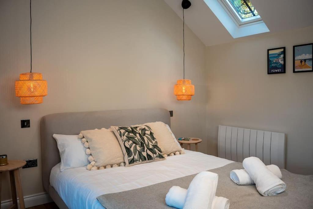a bedroom with a bed with white pillows and lights at The Stables, converted barn outside York in York