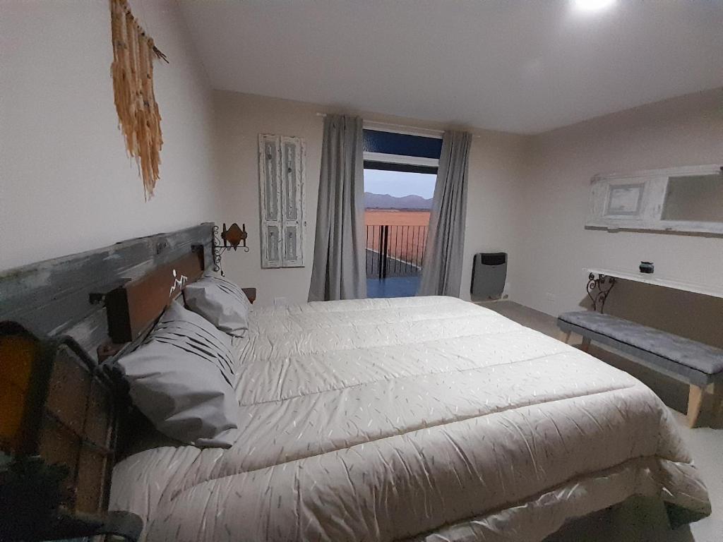 ein Schlafzimmer mit einem großen Bett und einem Fenster in der Unterkunft Apart Fincas de San Pablo in Deán Funes