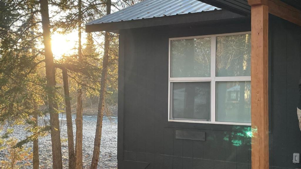 Una casa negra con una ventana en el costado. en River's Edge Retreat en Clearwater