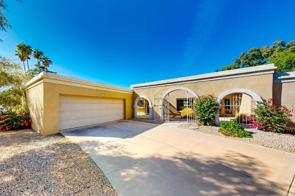 uma casa grande com garagem e palmeiras em Pink Bloom Sanctuary em Scottsdale