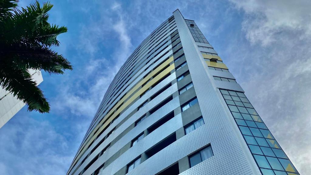 a tall white building with a palm tree at Natal Plaza in Natal