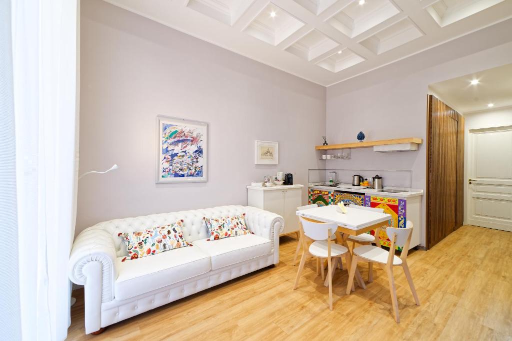 sala de estar con sofá blanco y mesa en La porta di mezzo, en Catania