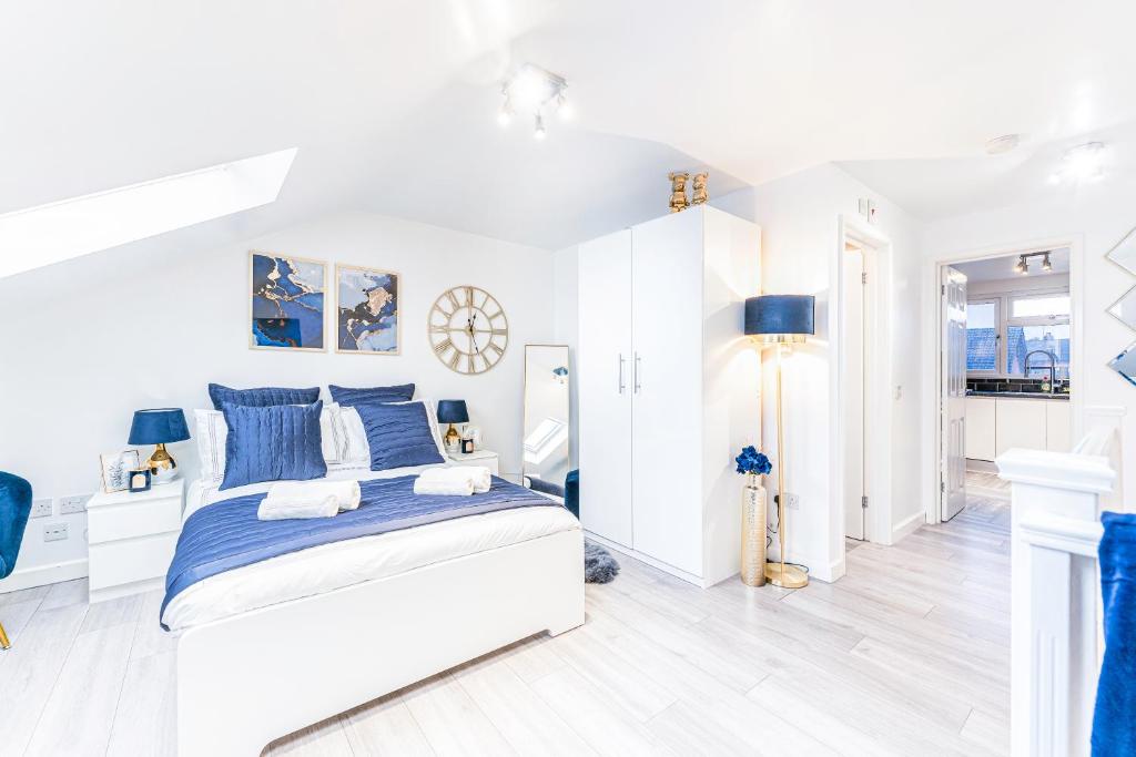 a white bedroom with blue and white furniture at Luxury Hideaway, City Centre,Parking,Netflix Sleeps 3 in Coventry