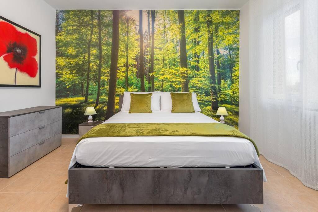 um quarto com uma cama com uma pintura de uma floresta em VillaPino 27 - New Apartment Como em Lucino