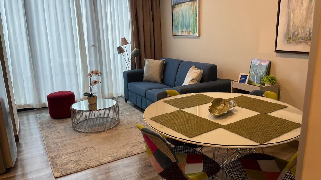 a living room with a table and a blue couch at Cozy apartment with terrace, SJ Cosmopolitan Tower in San José