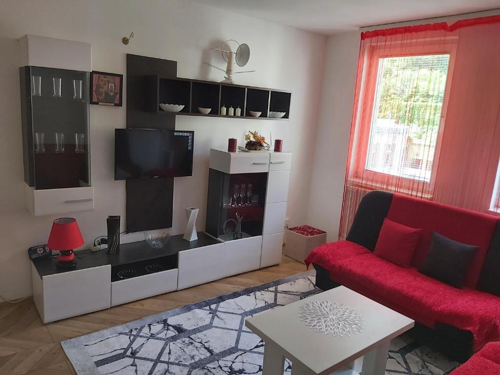 a living room with a red couch and a flat screen tv at xxxx in Zvornik