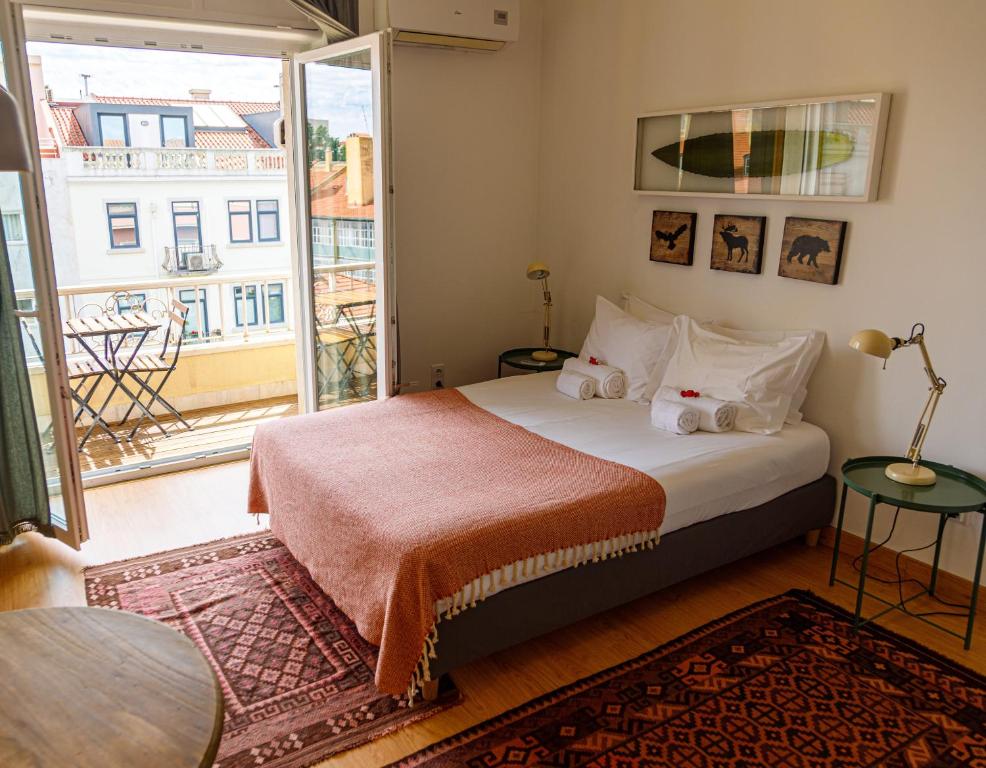 a bedroom with a bed and a large window at O Quinto Esquerdo in Lisbon