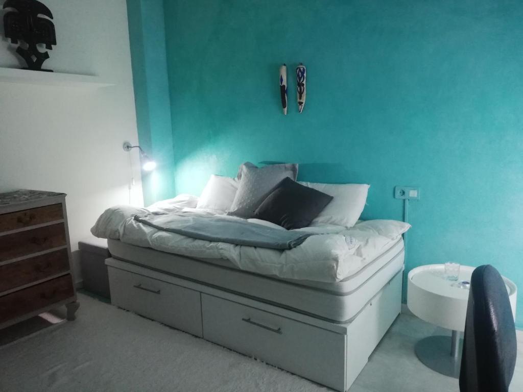 um quarto com uma cama com uma parede azul em comfortable single bluing room b&b em Granada