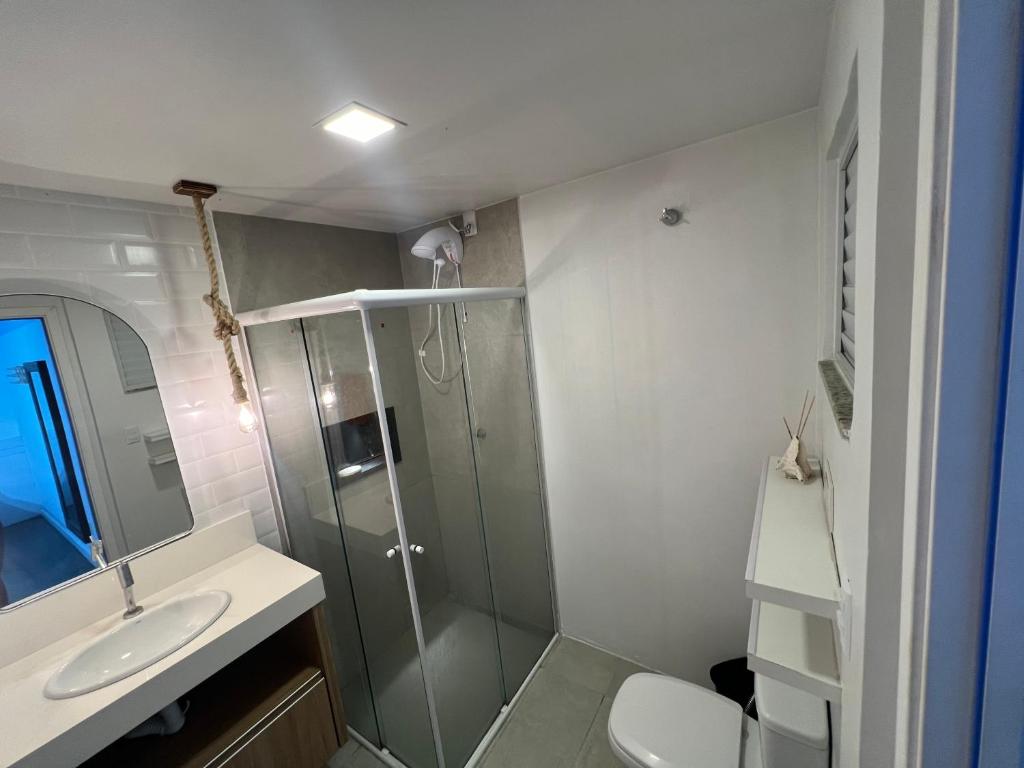a bathroom with a shower and a toilet and a sink at Pousada Ilha do Campeche in Florianópolis