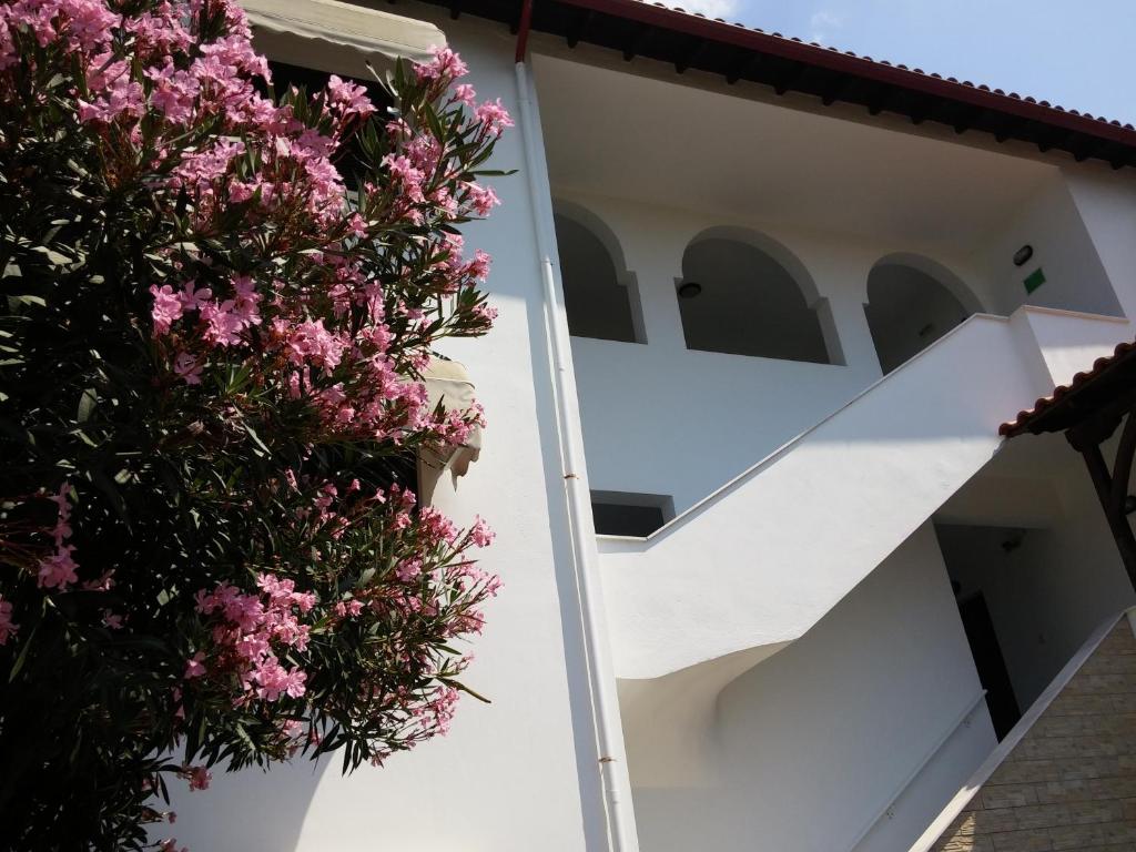 a white house with pink flowers on the side at Nikos & Panagiota in Vourvourou