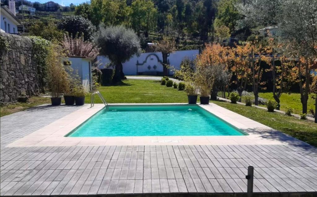 uma piscina no meio de um quintal em Beautiful villa in Póvoa de Lanhoso with pool and garden em Póvoa de Lanhoso