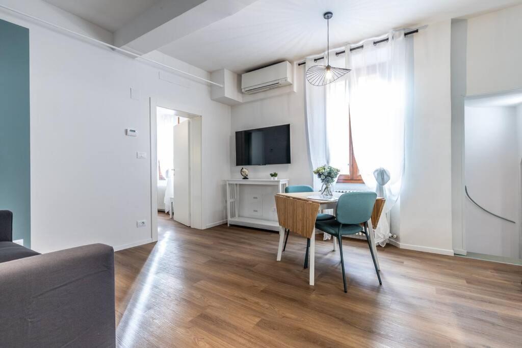 een woonkamer met een tafel en stoelen en een televisie bij Moline Home, in the City Center in Bologna
