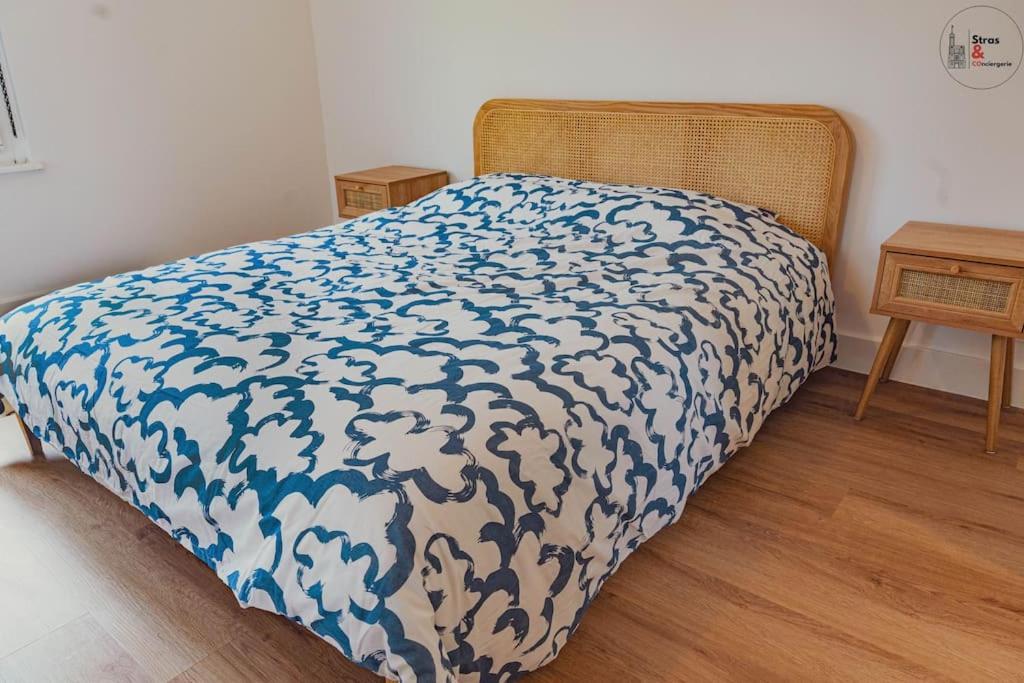 uma cama com um cobertor azul e branco em Le reflet chic - 2 pièces neuf - quartier calme à 5 min de Strasbourg em Schiltigheim