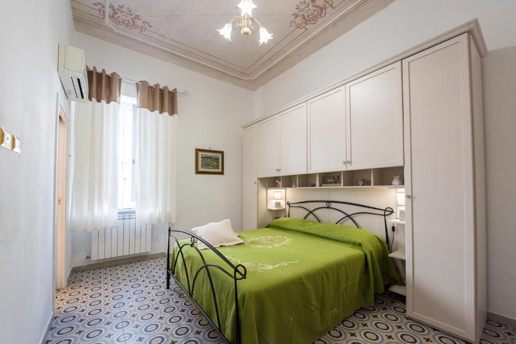 サレルノにあるLe Bijou Luxury Apartmentのベッドルーム(緑のベッド、白いキャビネット付)